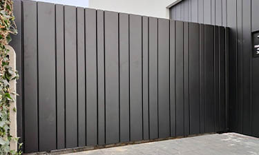 Strakke gesloten aluminium design poort uit lamellen motief - Zonhoven